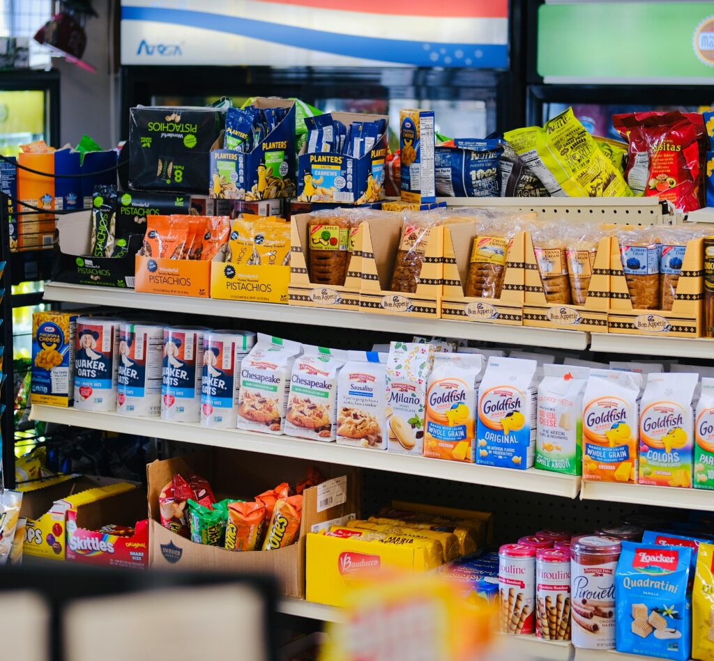 A variety of packaged snacks and sweets displayed on store shelves.