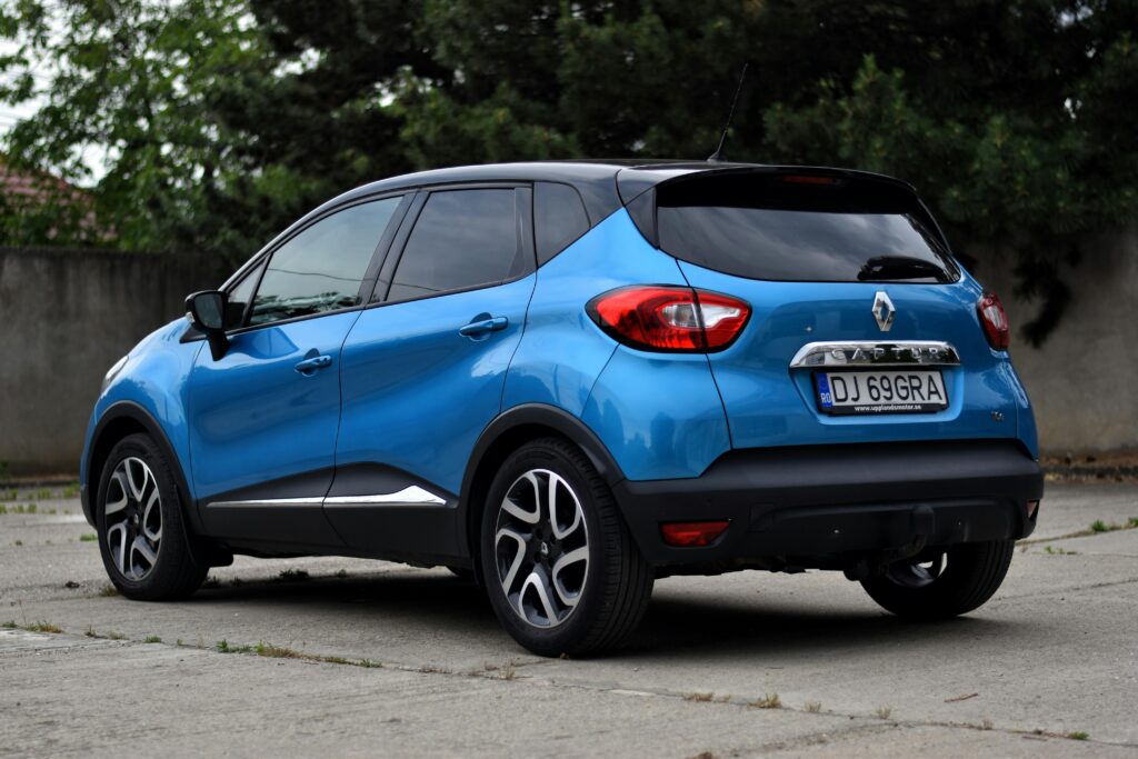 Blue Renault Captur parked outdoors showcasing rear view design and alloy wheels.