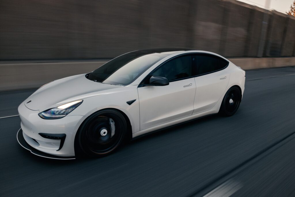 A smooth rolling shot of a white electric car on a highway in Philadelphia.