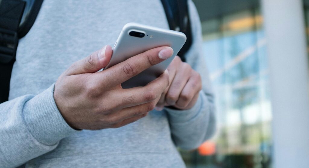 A person using a smartphone outdoors, emphasizing connectivity and modern communication.