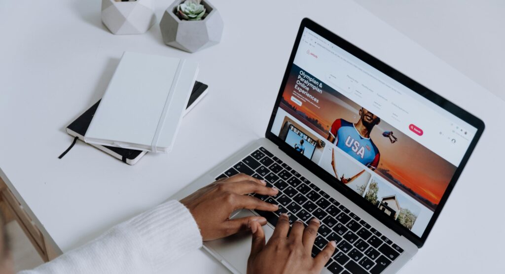 Close-up of hands typing on a laptop in a modern workspace. Minimalist, clean aesthetic.