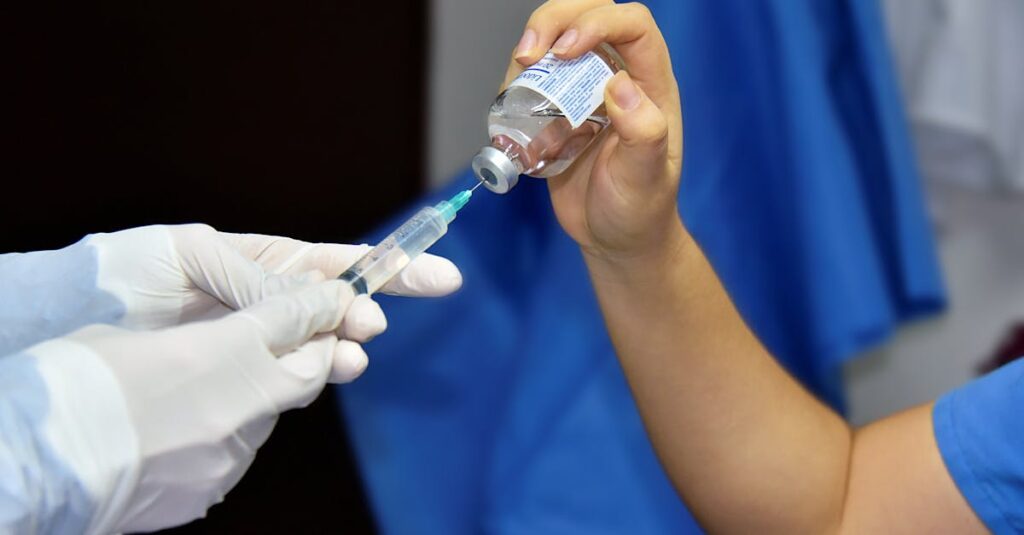 Close-up of healthcare worker filling a syringe from a vial, demonstrating vaccination or medical procedure.