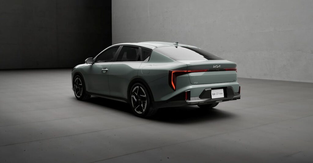 A modern gray Kia K4 GT Line vehicle in a minimalist indoor environment.