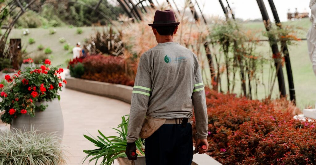 A gardener tends to plants in a vibrant botanical garden under an arched structure.