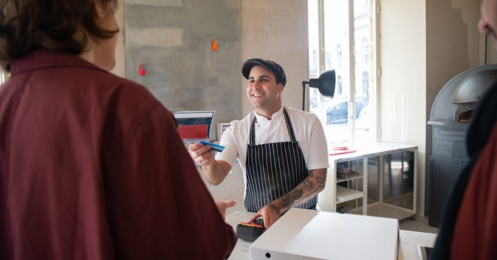 Chef smiling while serving a customer at a pizzeria in Portugal.