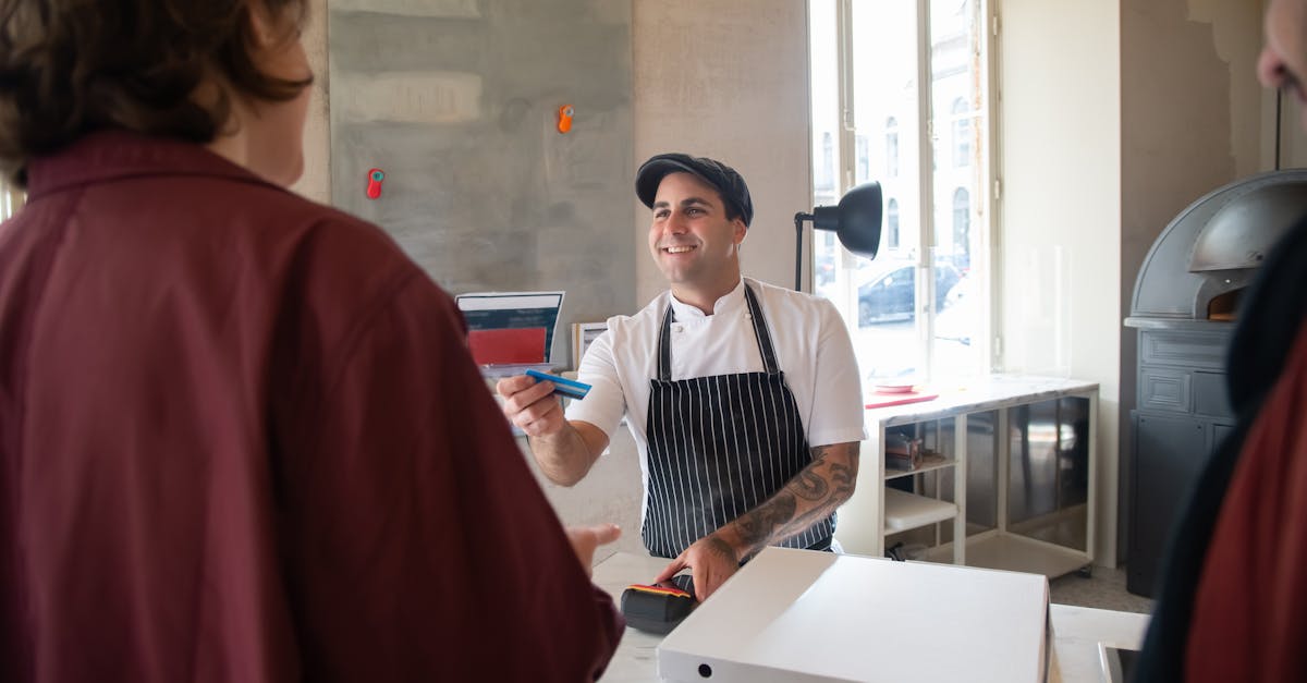 Chef smiling while serving a customer at a pizzeria in Portugal.