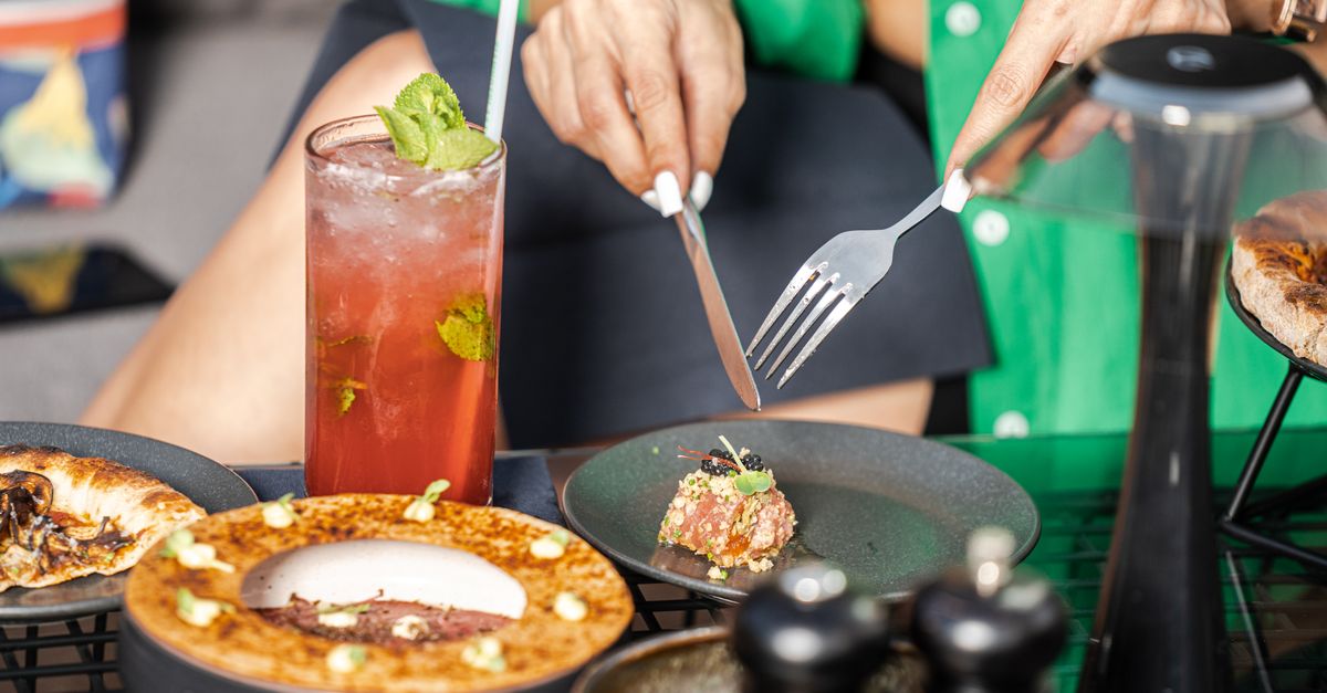 Elegant dining setup with artisanal dishes and a refreshing cocktail, perfect for a luxurious dining experience.