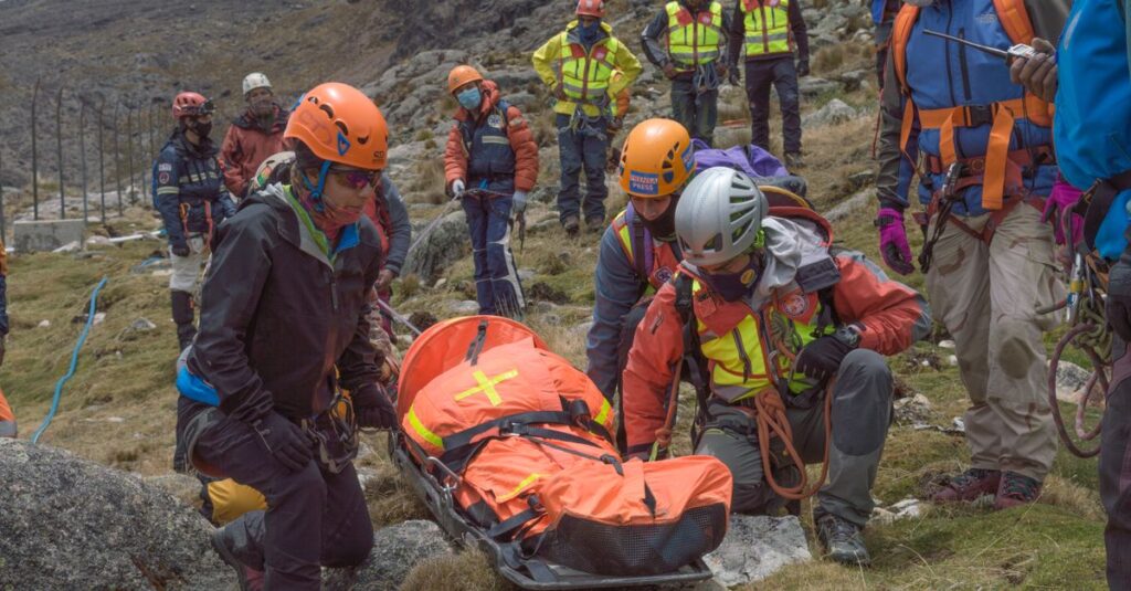 Rescue team performs mountain rescue using a stretcher to aid an injured hiker.
